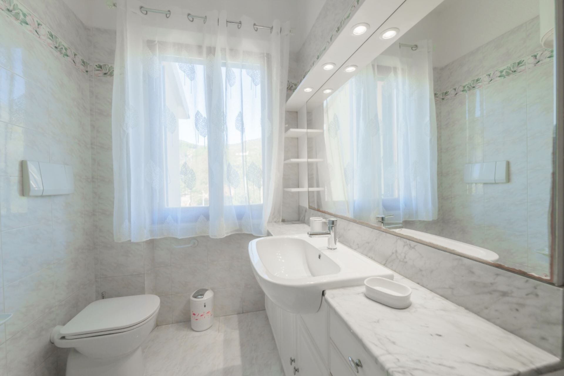 Een moderne badkamer met toilet, wastafel en bad.