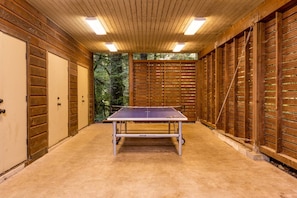 Enjoy a game of ping pong on the carpeted floor, surrounded by a forest view through the large window.