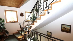 A staircase with wrought iron railings, wooden steps, and a view of the upper floor. - Spacious holiday apartment in Aschau (Aschau im Zillertal)