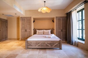 A bedroom with a large bed, wooden headboard, and a ceiling fan.