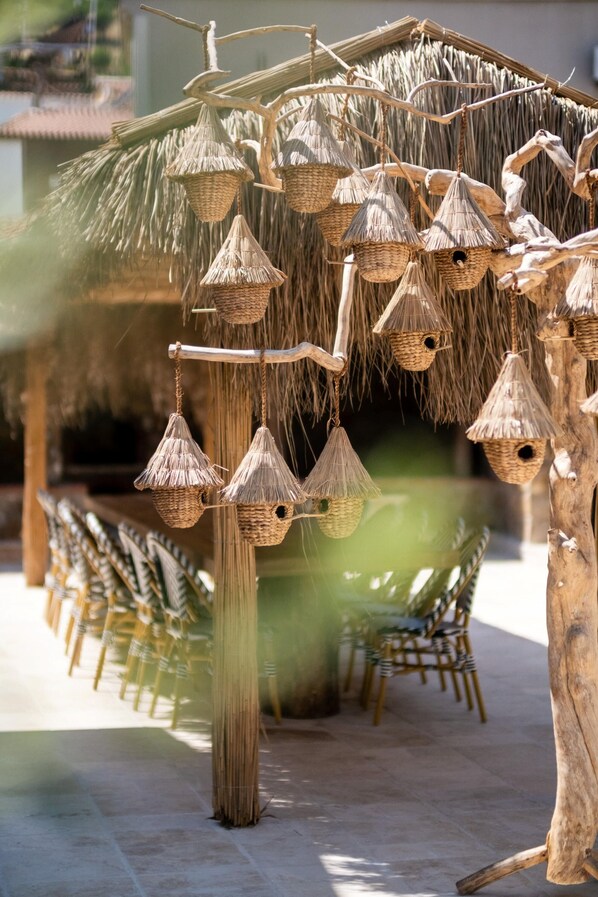 A structure with multiple hanging woven baskets, likely used for decorative or functional purposes. - Bi Ada Otelleri (Bozcaada)