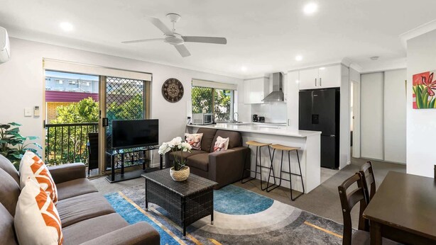Un appartement moderne comprenant un salon, une cuisine et un coin repas.