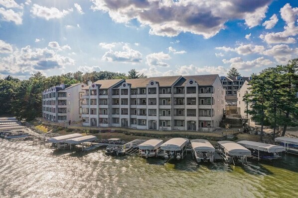 A multi-story hotel with a central courtyard, surrounded by water and docked boats.