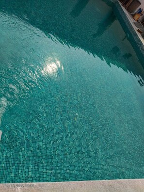 Vista despejada de una piscina con fondo de azulejos.