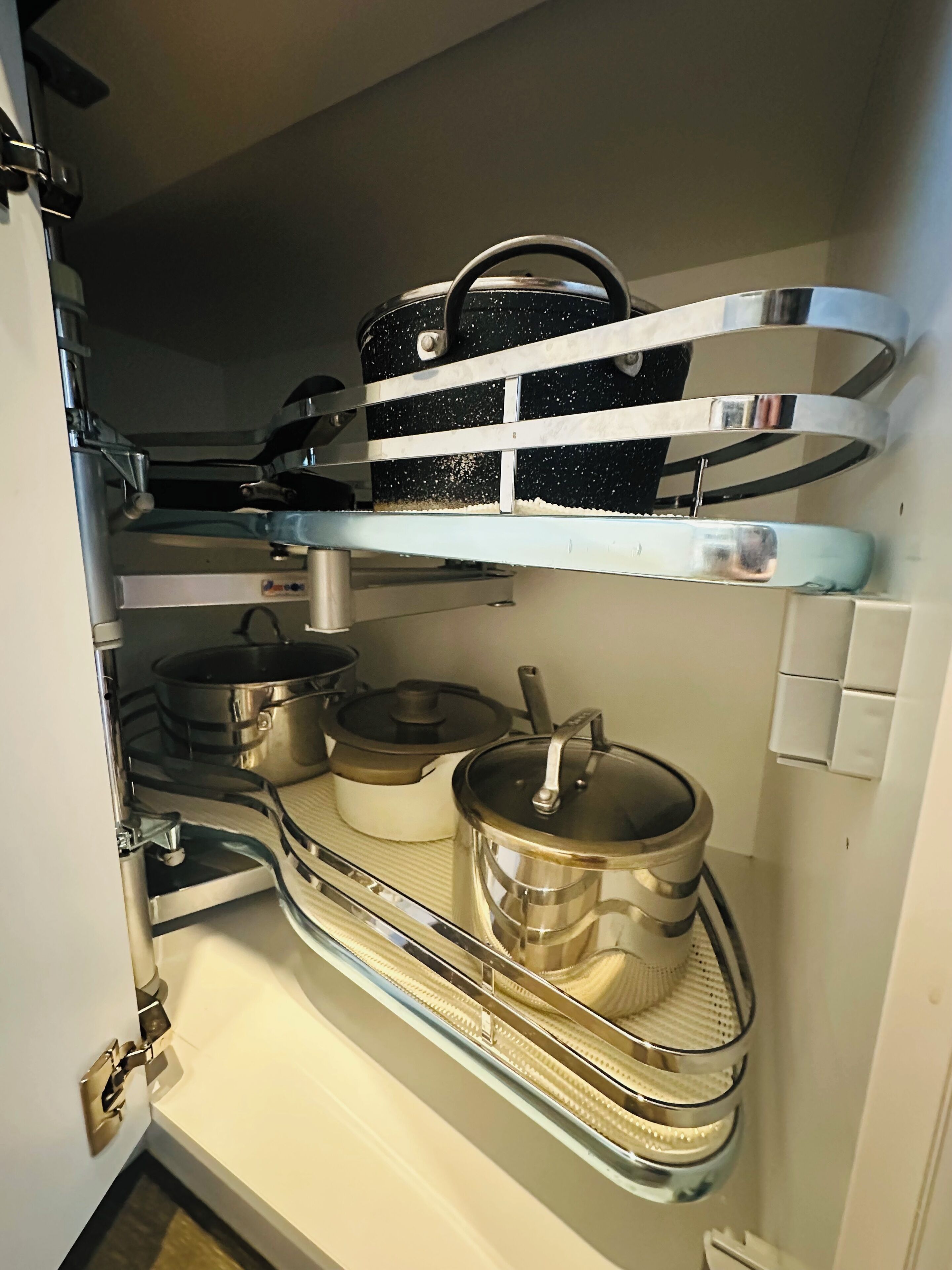 Una cocina con electrodomésticos de acero inoxidable y utensilios de cocina ordenados en estantes.
