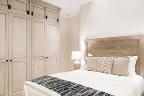 Ein Schlafzimmer mit einem großen Bett, einem Holzkopfteil und einem Schrank mit mehreren Türen.