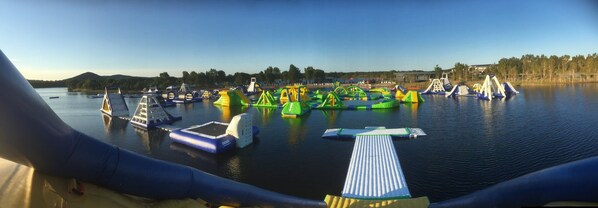 Un parc aquatique doté de diverses structures de jeux gonflables et d’un quai.