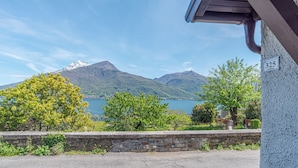 A stone wall with a view of a lake and mountains. - Casa Achille Pianello (Pianello del Lario)