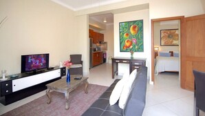 A modern living room with a television, sofa, coffee table, and artwork.