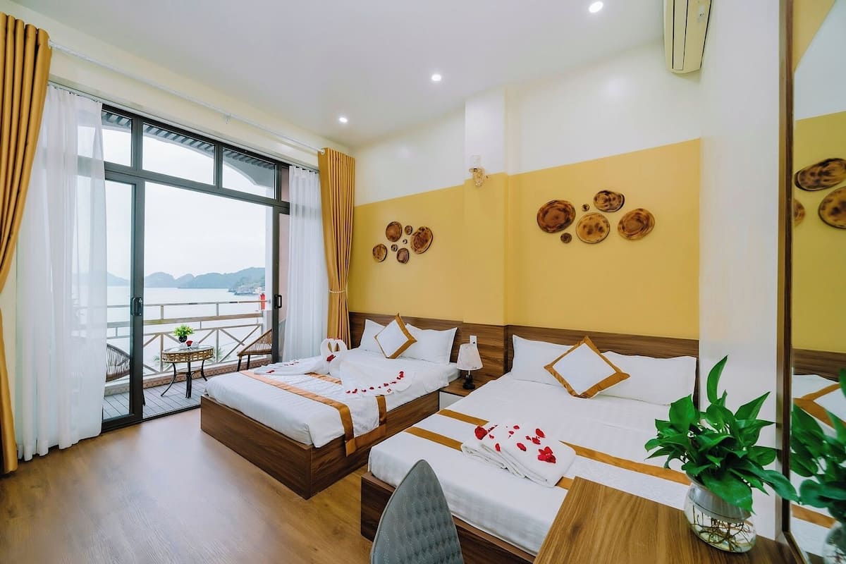 A hotel room with two beds, a balcony with a view, and a large mirror.