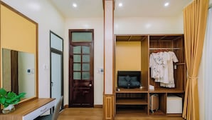 A hotel room with a wooden desk, a TV, a wardrobe, and a mirror. - Gia Cat Long Hotel (Hai Phong)