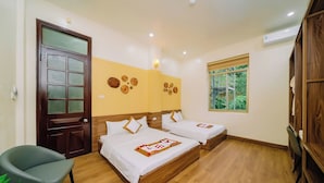 A room with two beds, a wooden door, a window, and a chair. - Gia Cat Long Hotel (Hai Phong)