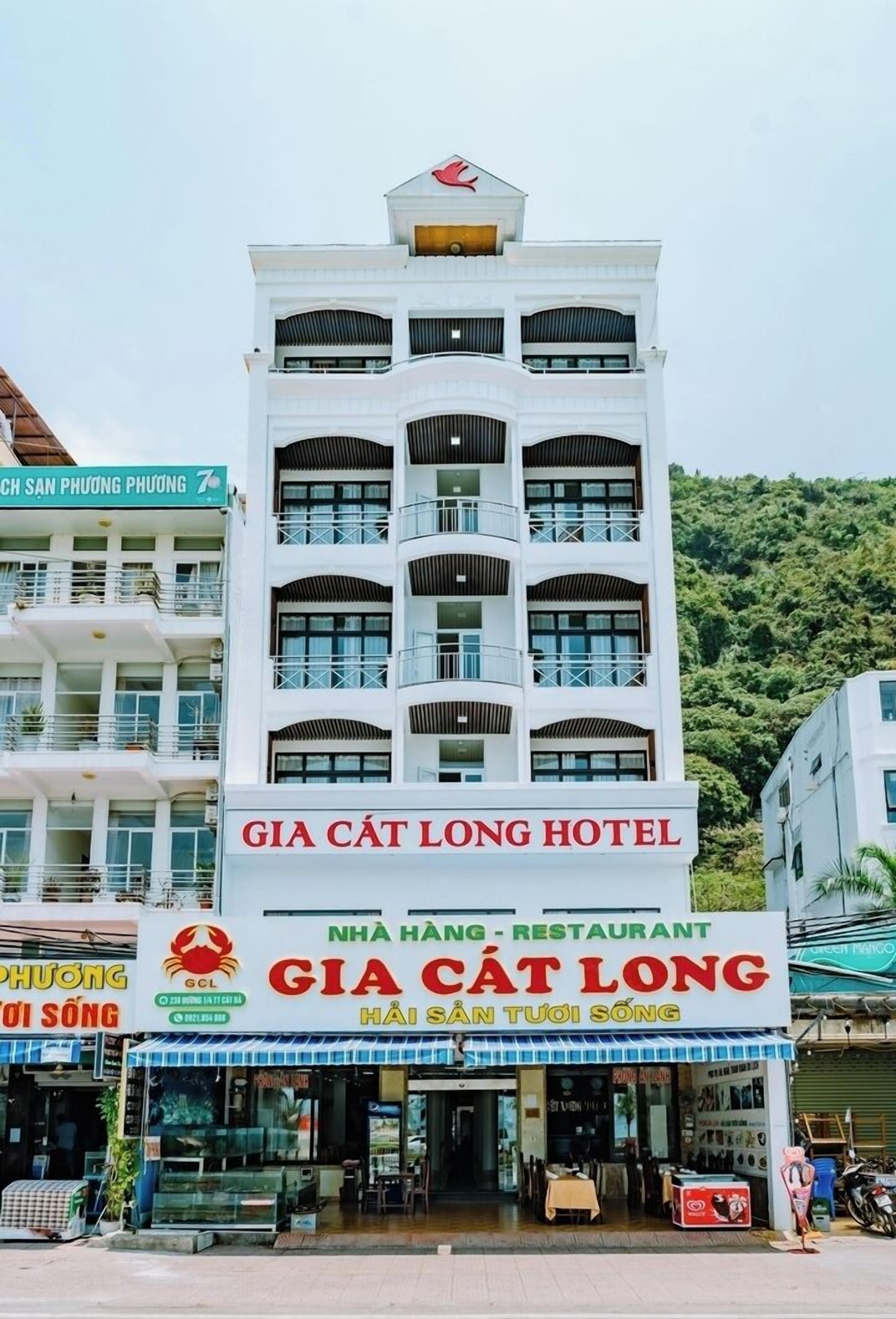 Un edificio de varios pisos con un letrero que indica el Hotel Gia Cat Long y un restaurante llamado Gia Cat Long.