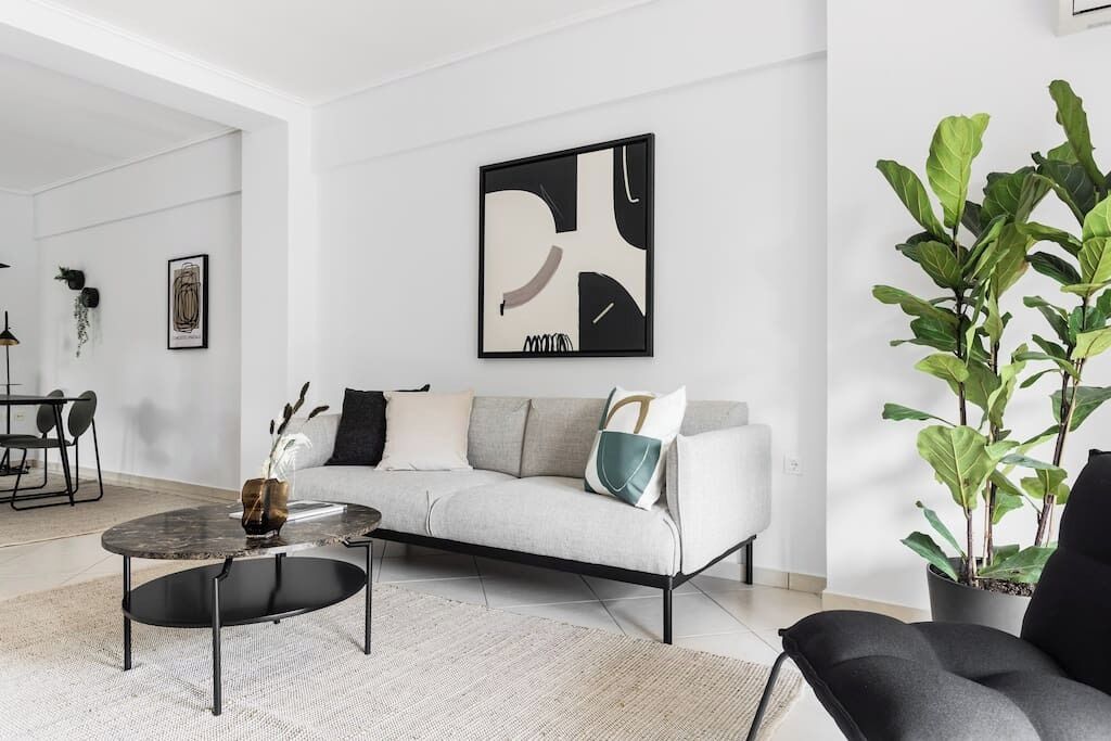 Un salon moderne avec un canapé, une table basse et des plantes en pot.