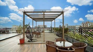 Enjoy al fresco dining and city views from this rooftop terrace with a shaded deck and comfortable seating.
