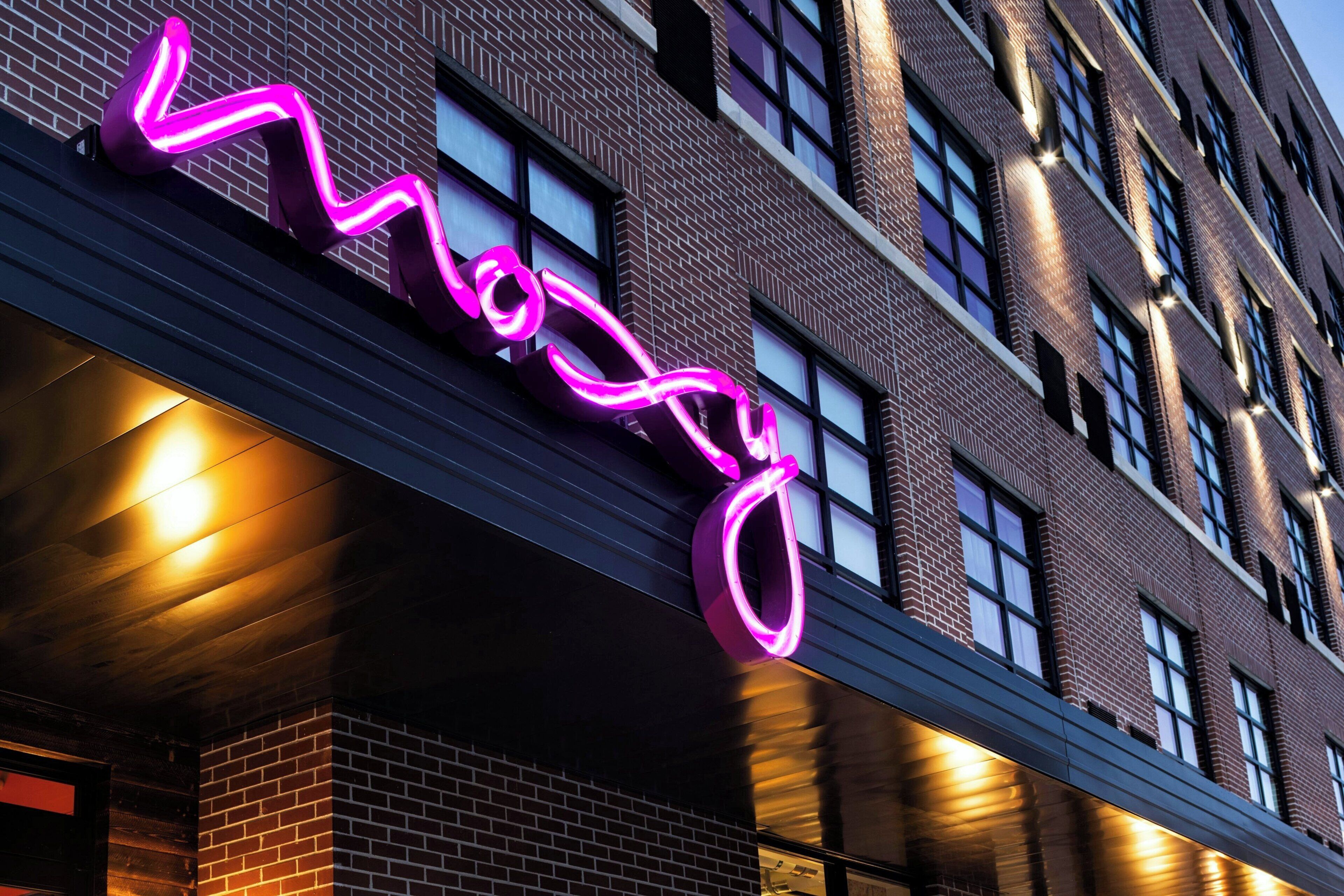 A building with a neon sign spelling "Moss" in a stylized font.