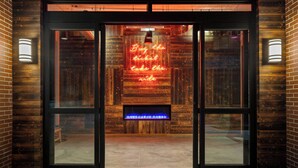 A wooden facade with a neon sign that reads "Buy the ticket take the ride." - Moxy Omaha Downtown (Omaha)