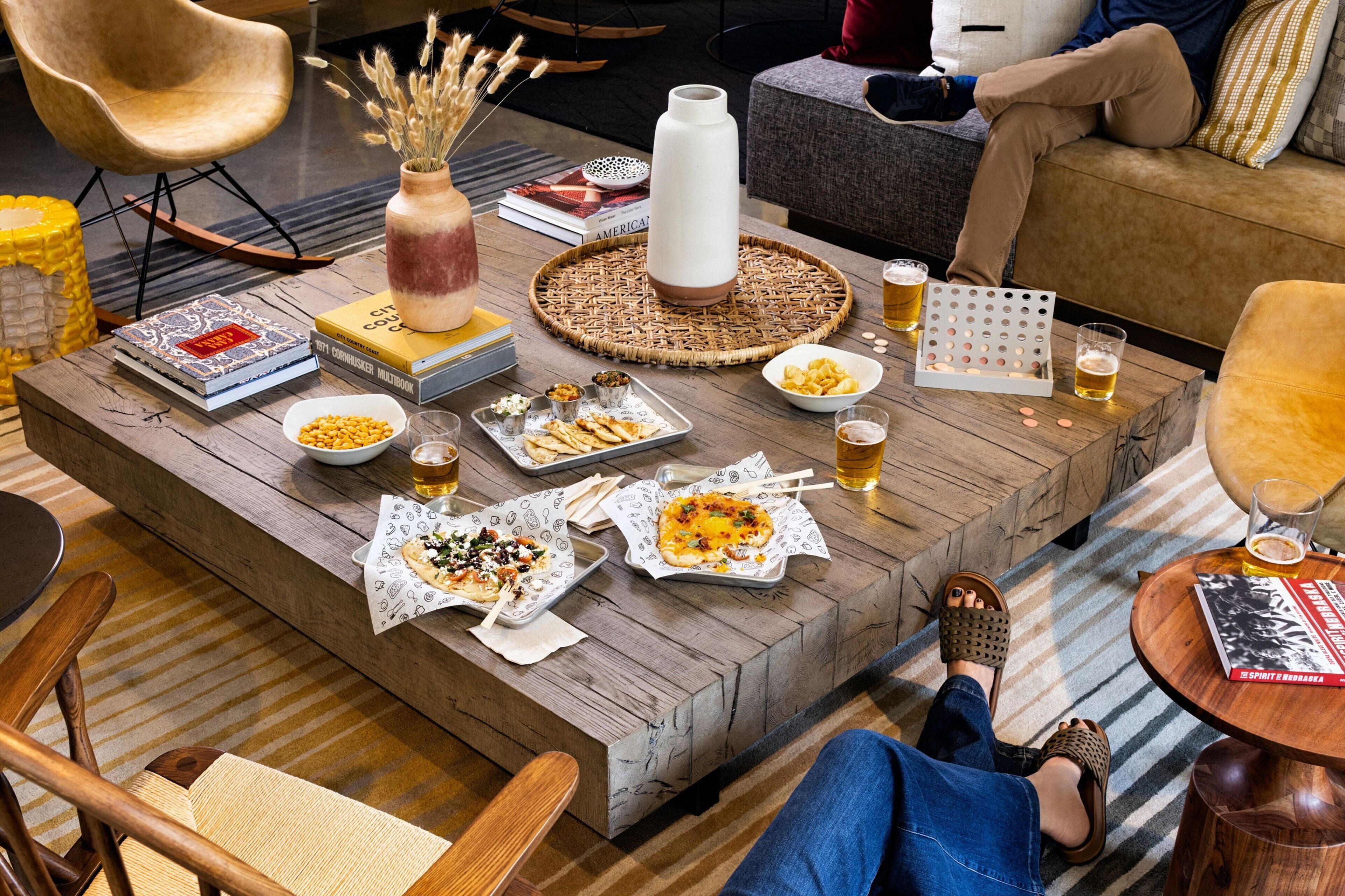 A cozy living area with a wooden coffee table, books, and snacks.