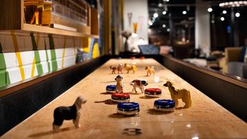 Une table de jeu de palet avec de petites figurines de chiens et des palets numérotés.
