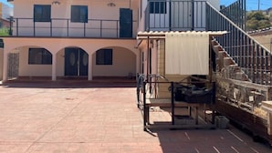 Un bâtiment à deux étages doté d’un balcon et d’un espace extérieur abrité.
