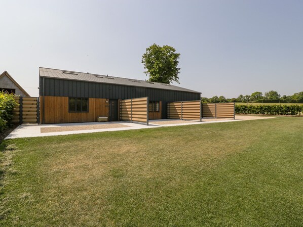 Un bâtiment moderne doté d’un toit plat, de grandes fenêtres et d’une façade en bois.