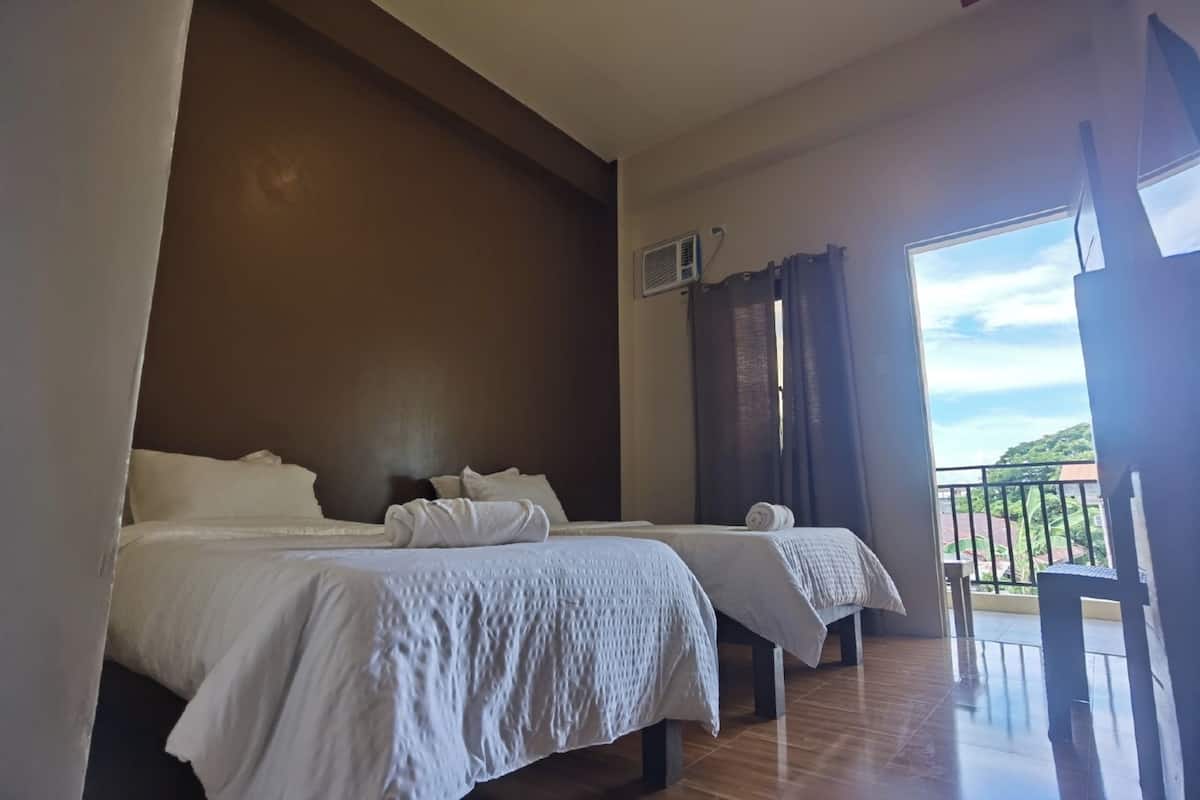 Ein Hotelzimmer mit zwei Betten, einem Balkon und Blick auf die Landschaft.