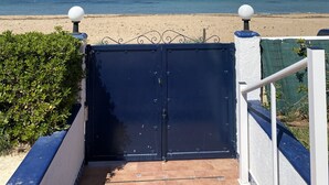 Un cancello che dà accesso a una spiaggia con vista diretta sull'oceano.