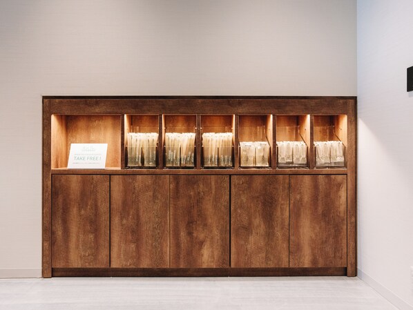 A wooden reception desk with a sign offering free amenities.