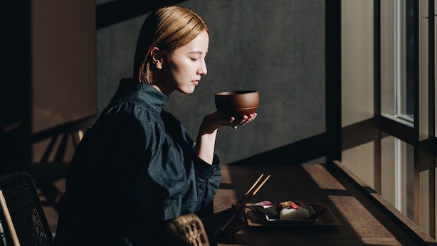 A person sitting by a window with a meal and chopsticks on a tray. - Prince Smart Inn Miyazaki (Miyazaki)
