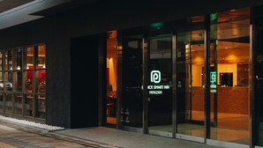 A modern hotel entrance with glass doors, a visible reception area, and a sign indicating it is a 'Smart Inn'. - Prince Smart Inn Miyazaki (Miyazaki)