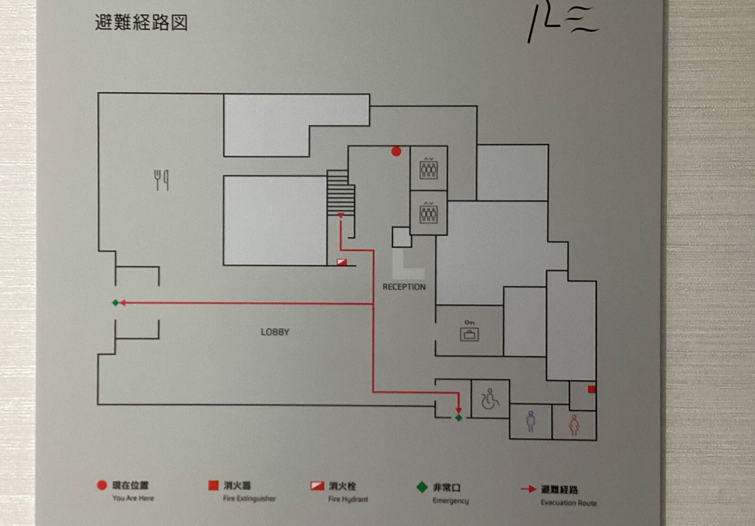 Un schéma simplifié d’un bâtiment indiquant les différents espaces, tels que le hall d’entrée, la réception et les sorties de secours.