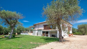 Une maison à deux étages dotée d’un porche couvert, d’une allée en gravier et d’une pelouse bien entretenue.