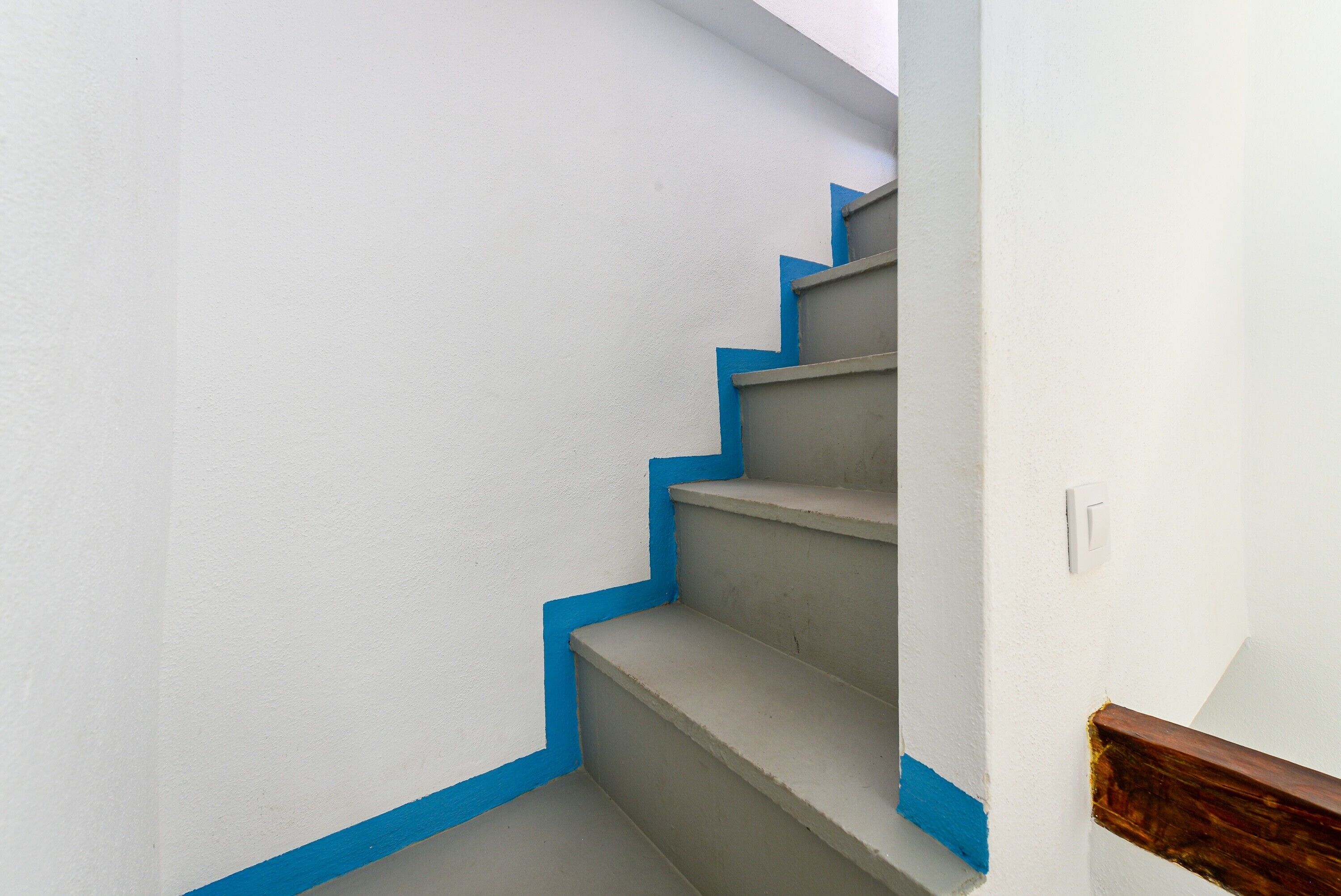 A staircase with blue trim and a wooden handrail.