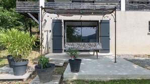 A patio area with a bench, potted plants, and a pergola with string lights. - Apartment "Gîte les Monteils" with Mountain View, Private Terrace & A/C (Vesseaux)