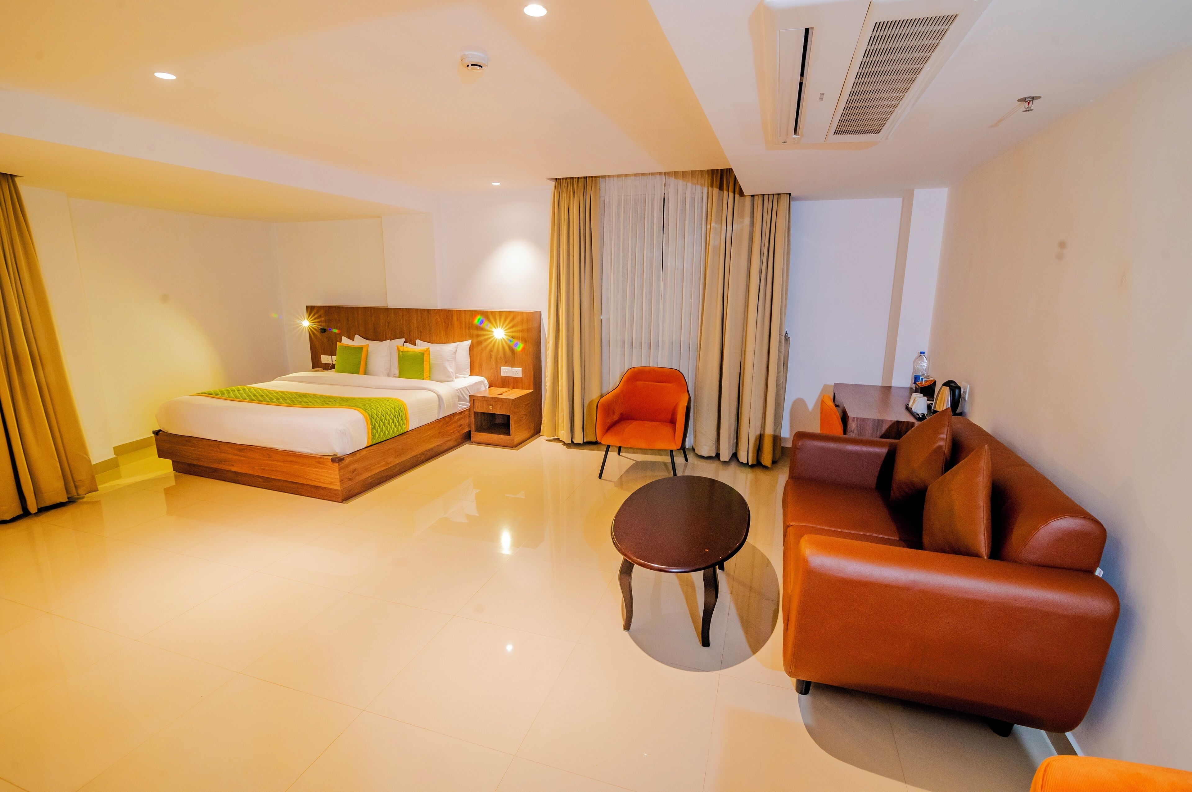 Una habitación de hotel con una cama, un sofá, una mesita y una silla.