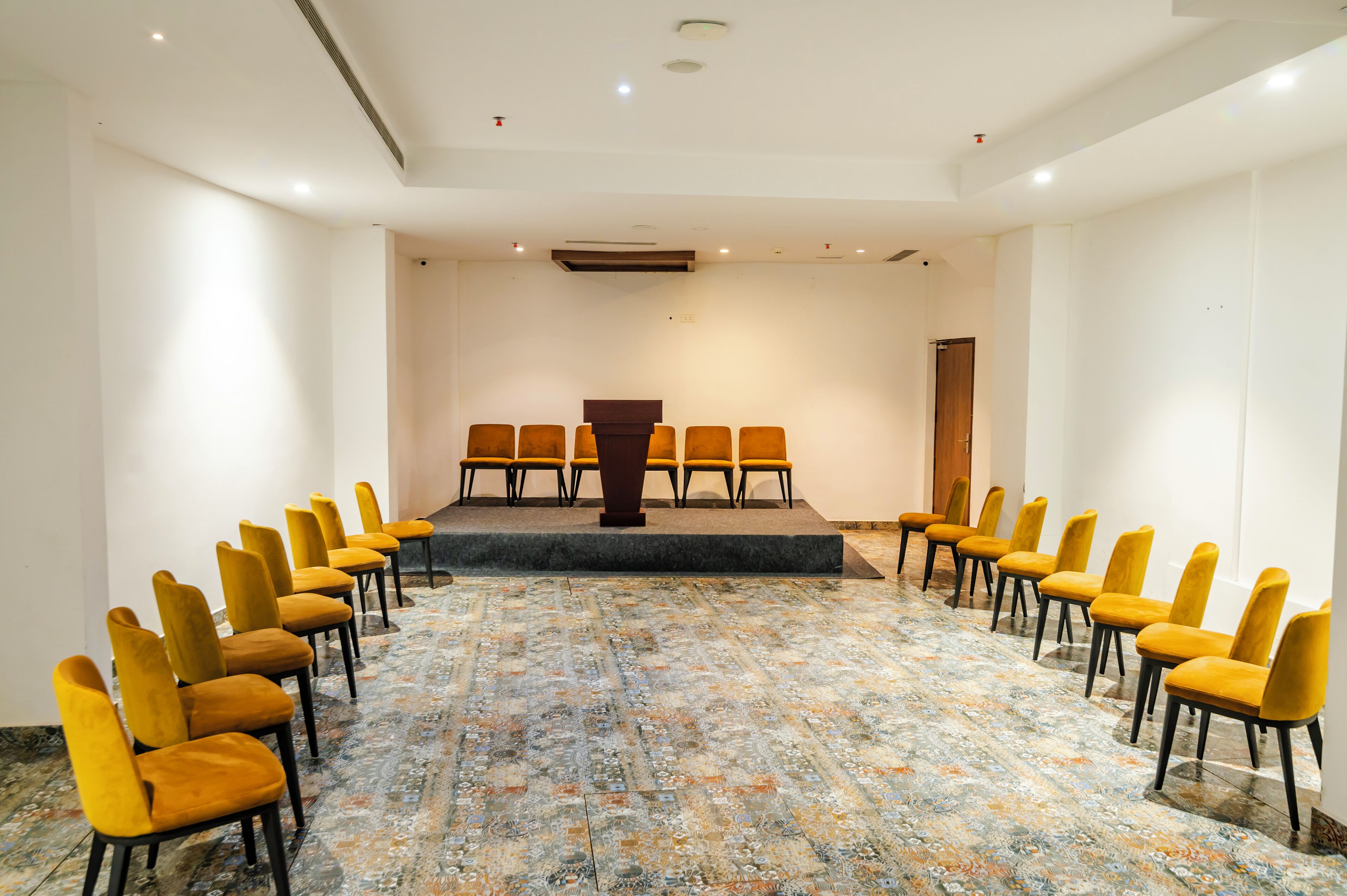 A conference room with a long table and rows of chairs facing it.