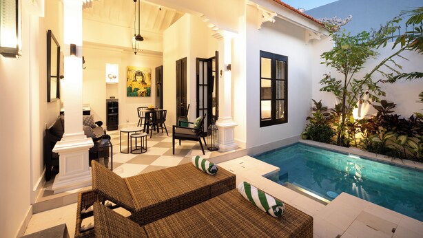 A poolside area with wicker furniture, a dining set, and a view of the pool. - Villa Martini Beachside 4 (Canggu)