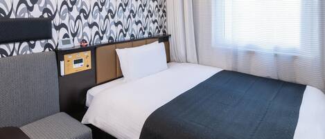 Quarto de hotel com cama, painel de controle, cabeceira, mesa de cabeceira e janela com cortinas.