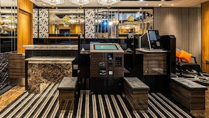 A modern hotel lobby with a reception desk, check-in kiosks, and a large chandelier. - APA Hotel Hatchobori Ekimae (Tokyo)