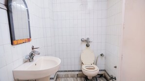 Un baño con un lavamanos blanco, un inodoro y un espejo.