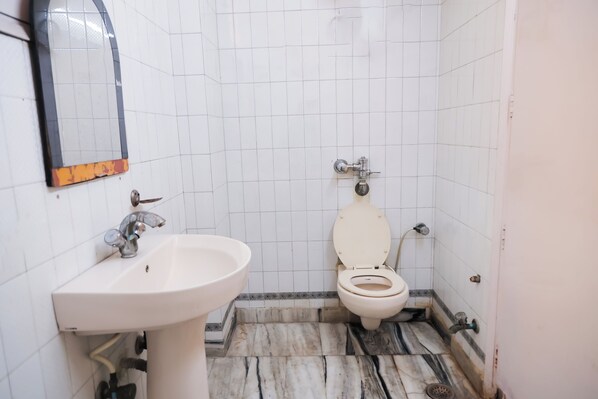 Un baño con un lavamanos blanco, un inodoro y un espejo.