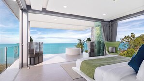 Une chambre moderne dotée d’un grand lit, d’un coin salon et offrant une vue sur l’océan.