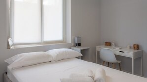 Quarto com cama, escrivaninha e cadeira.