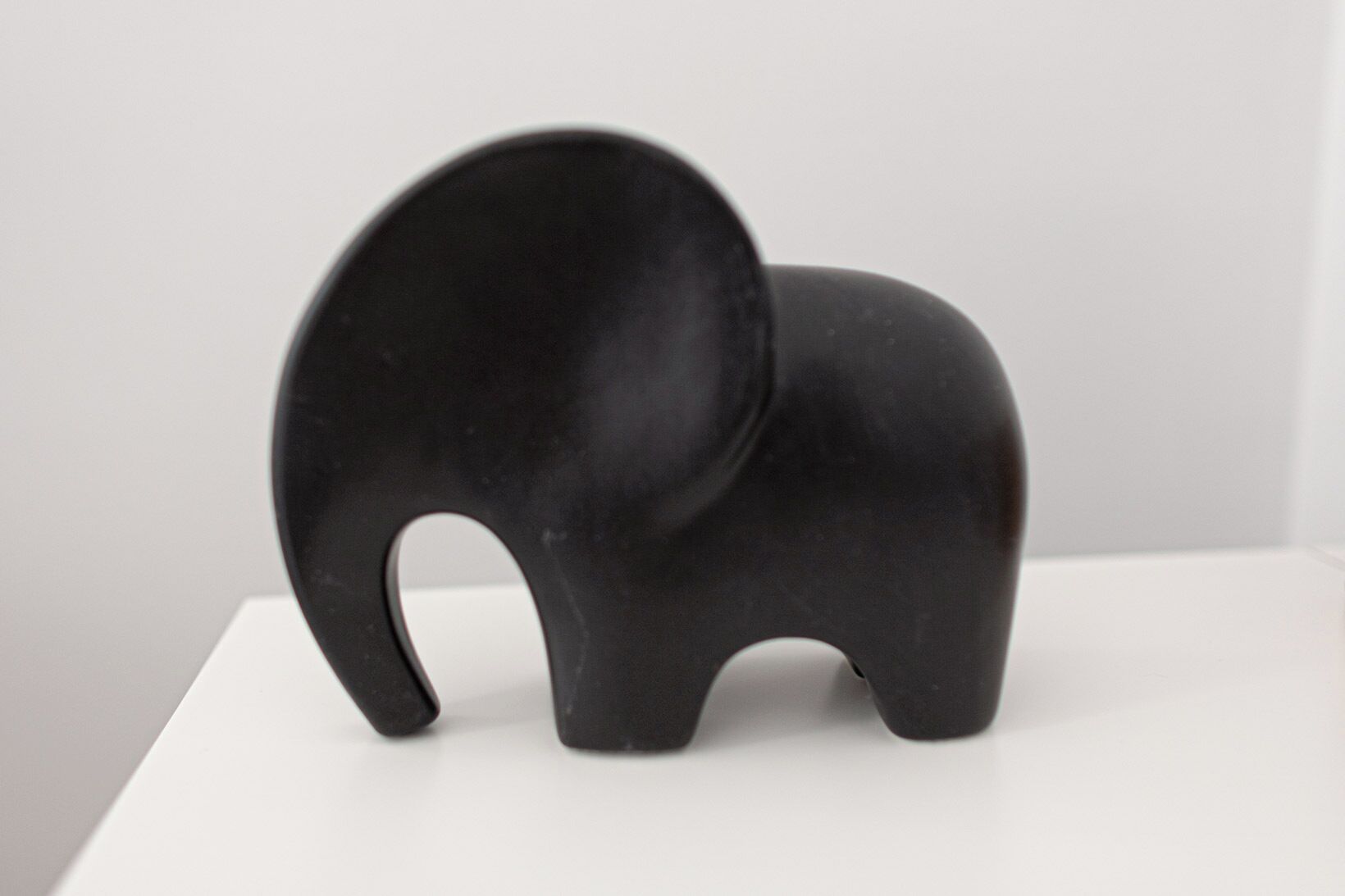A black elephant-shaped object on a white surface.