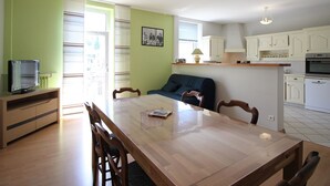 A compact living space with a dining area, kitchenette, and a sofa.