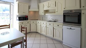 A kitchen with white cabinets, a microwave, a coffee maker, a sink, and a dishwasher.