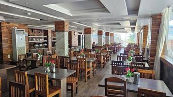 Enjoy a comfortable dining experience in our modern dining area with wooden tables and chairs.
