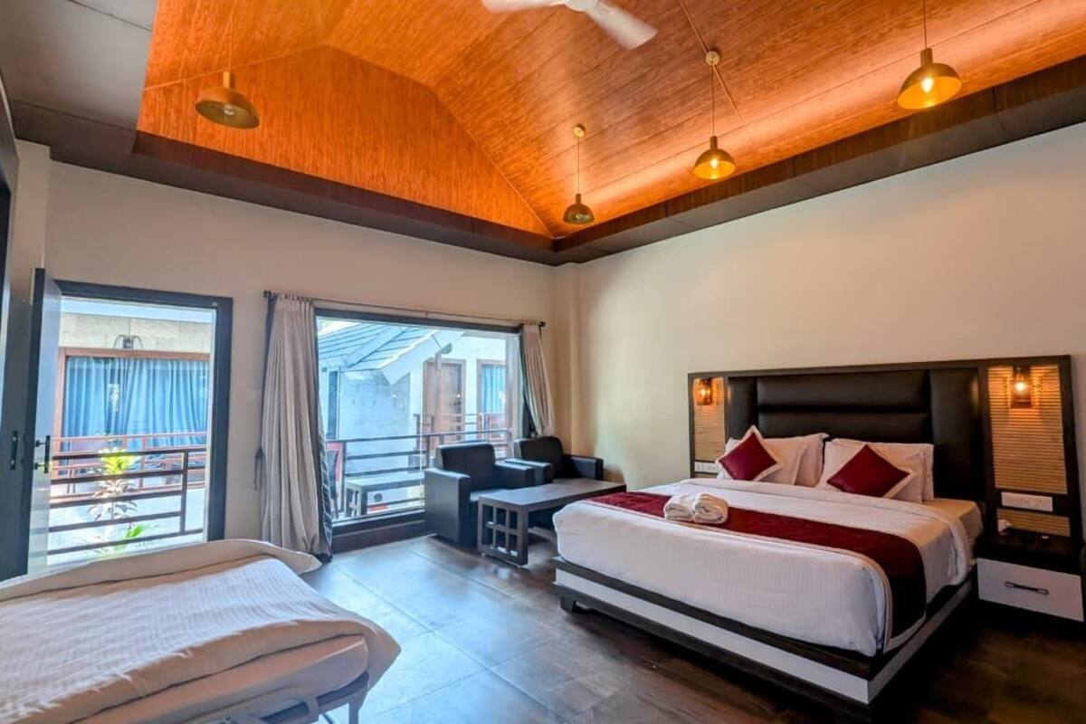 Une chambre d’hôtel avec un grand lit, un bureau et un balcon doté d’un espace salon extérieur.