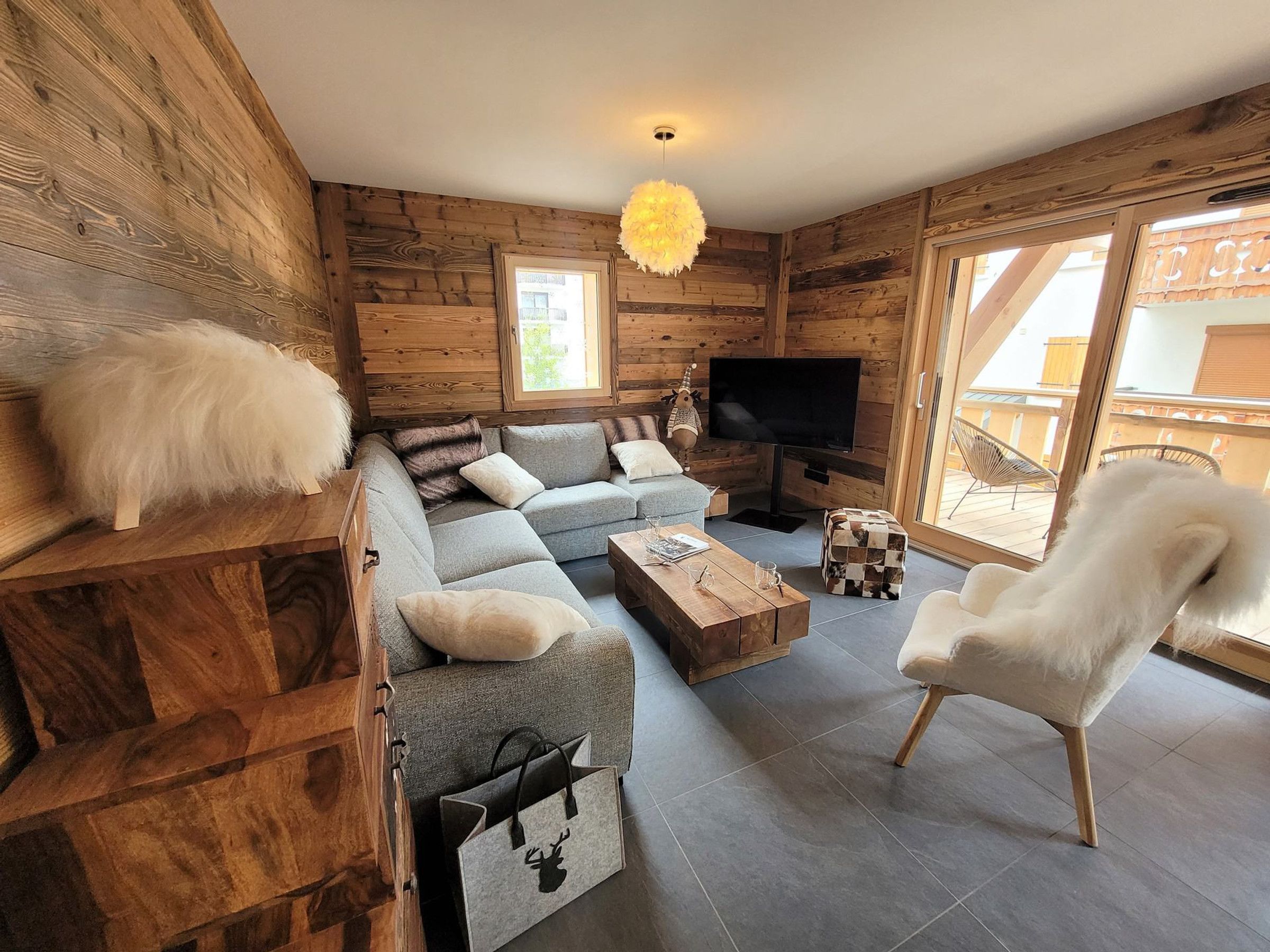 Un salon confortable avec un canapé, une table basse, un téléviseur et un fauteuil.
