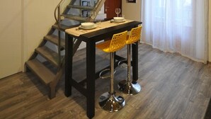 A dining area with a staircase, wooden flooring, and a table set for two. - Papireto 11 Loft |Charming cozy space at Cathedral (Palermo)